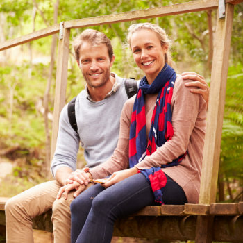 Happy couple sitting on a bridge