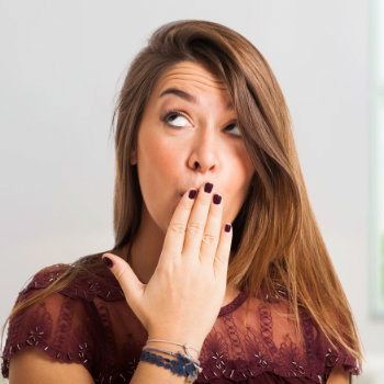 embarrassed brunette covers her mouth with her hand
