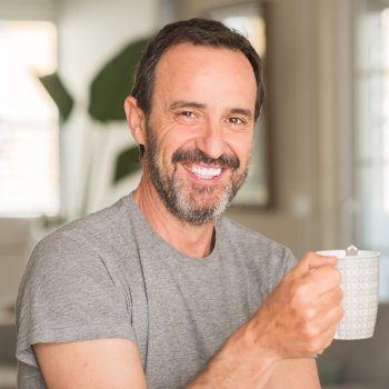 smiling middle aged man holding a cup