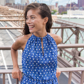 young asian woman smiling while standing on the bridge